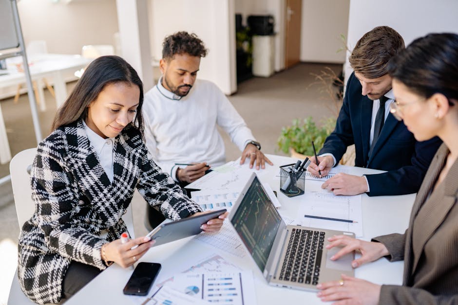 Team of employees in a bright office reviewing cybersecurity training materials together